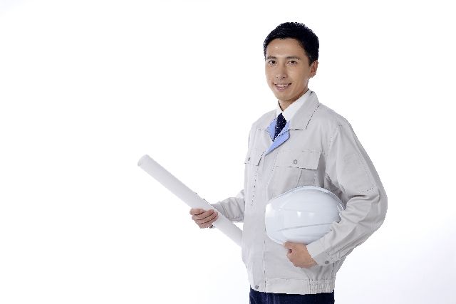 資料とヘルメットを持った作業服の男性