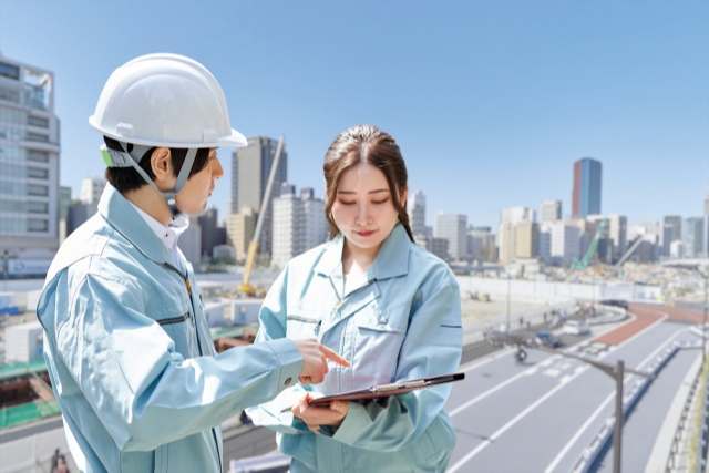 土木設計の書類を確認する二人の作業員
